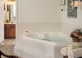 two person corner jacuzzi with wall art and electric candles