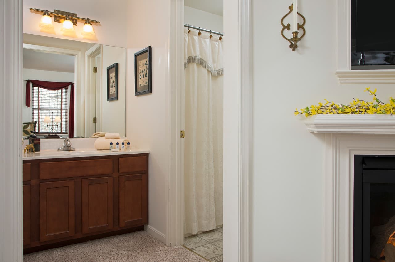 Vanity and sink with bathroom nearby