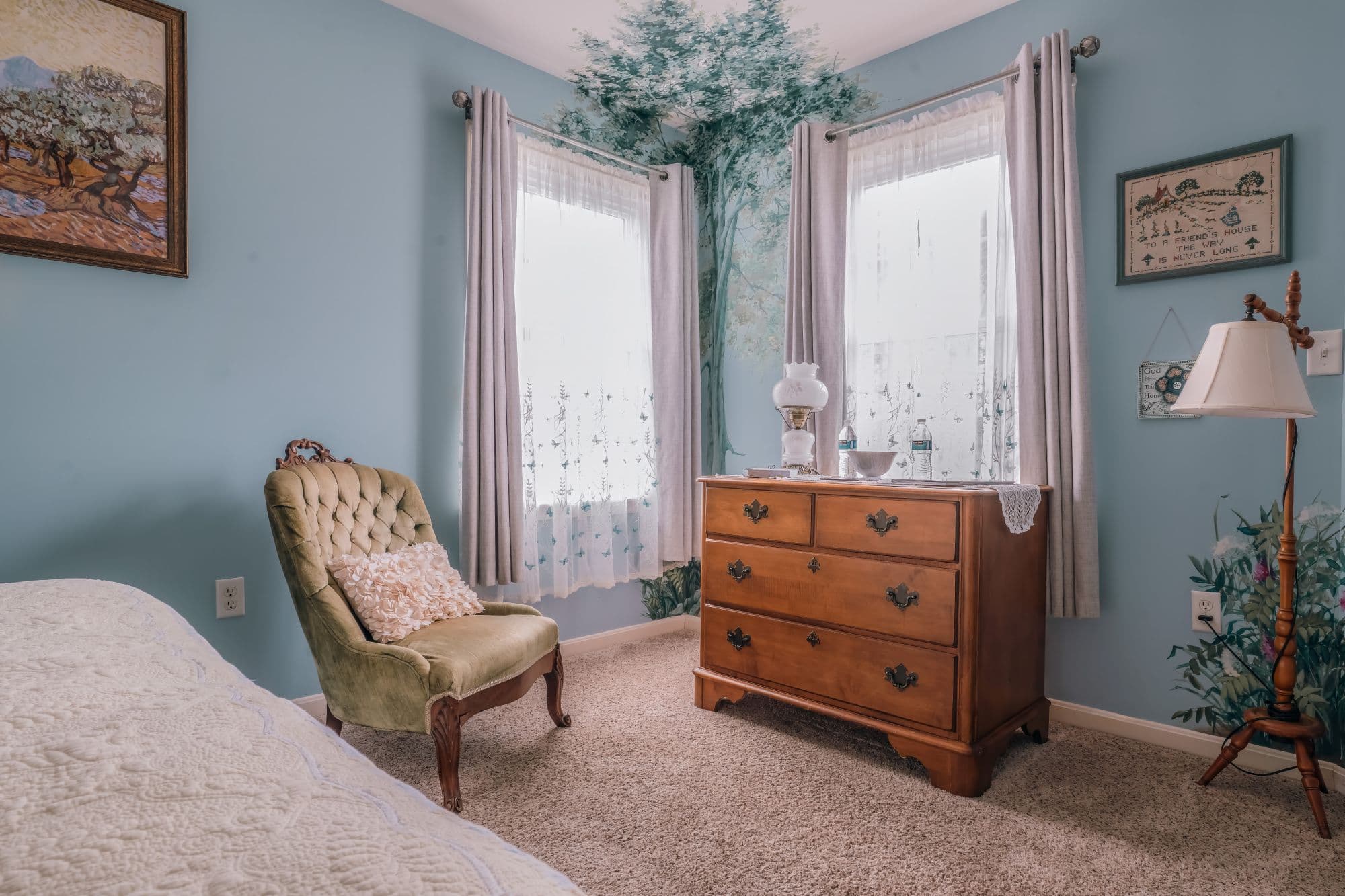 Alternate view of blue guest room showing seating area and tranquil pastoral-inspired design