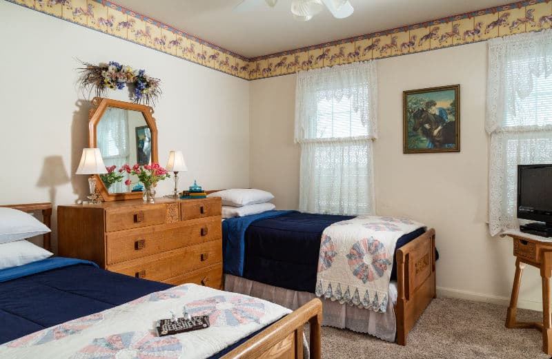 second room has two twin beds, a dresser and a TV