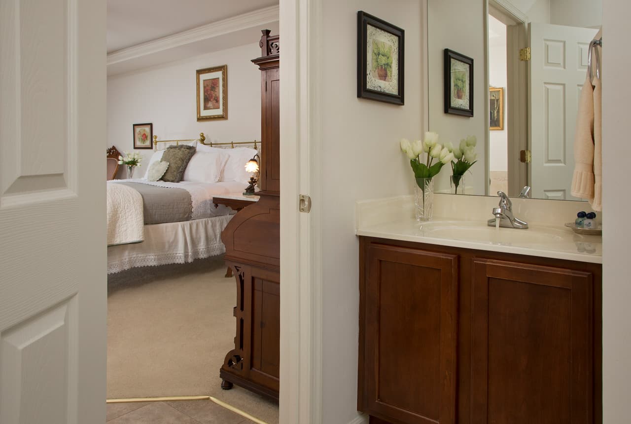 vanity in bathroom, looking out to main room with king size bed