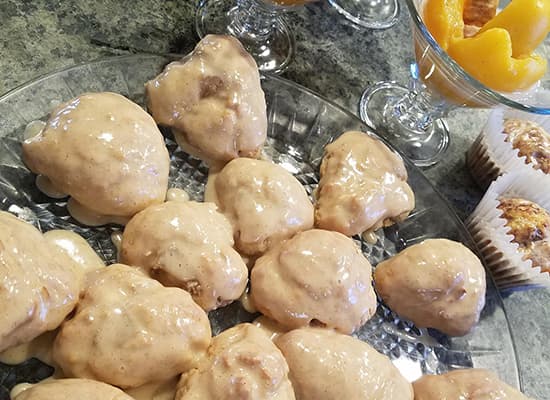 A platter of cream-covered pastries alongside dessert cups and muffins.
