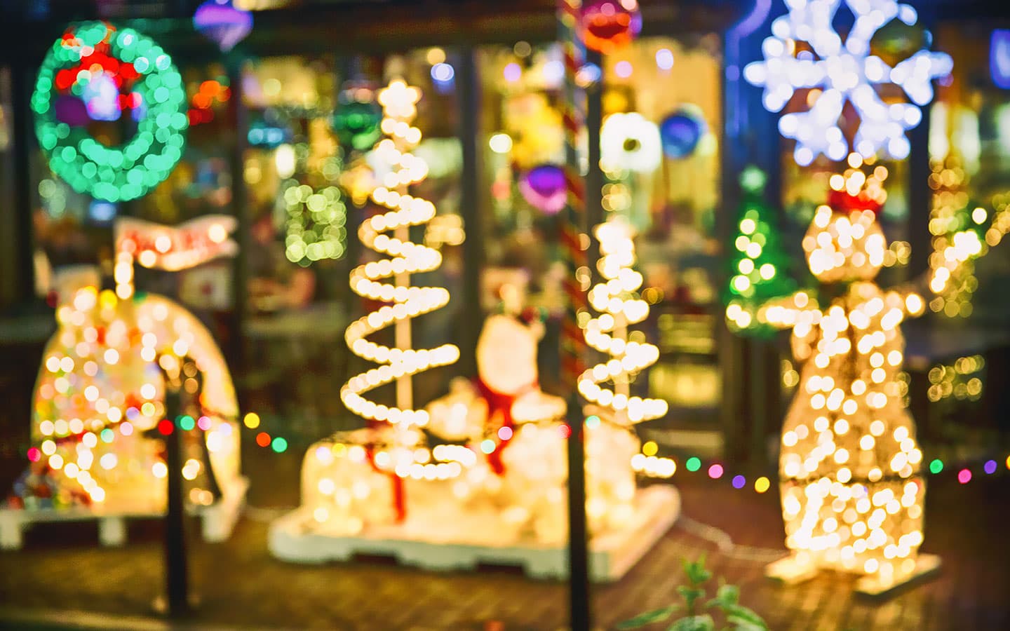 A festive display featuring Christmas lights shaped like a tree, a snowman, and holiday decorations.