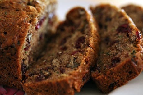 Slices of moist, nutty bread with cranberry pieces.