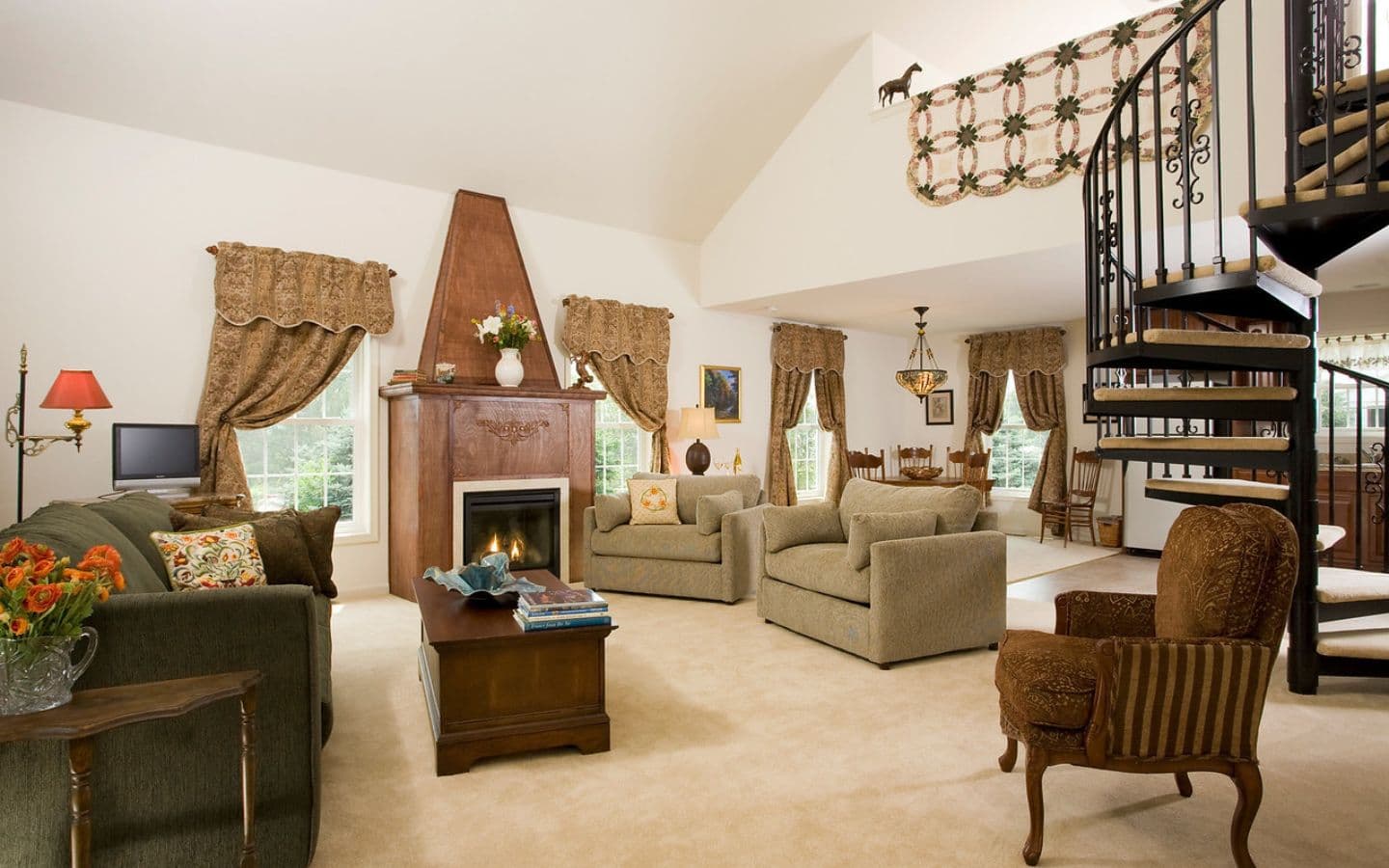 A well-furnished living room featuring a fireplace, comfortable seating, and a spiral staircase.