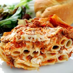 A serving of lasagna with meat sauce, cheese, and a side salad.