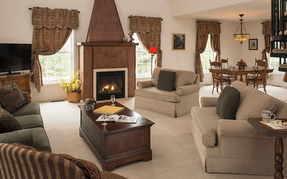 A cozy living room featuring a fireplace, comfortable seating, and a dining area with elegant decor.