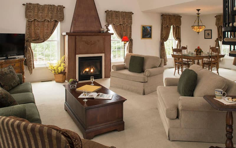 Cozy living room featuring a fireplace, comfortable seating, and a dining area.