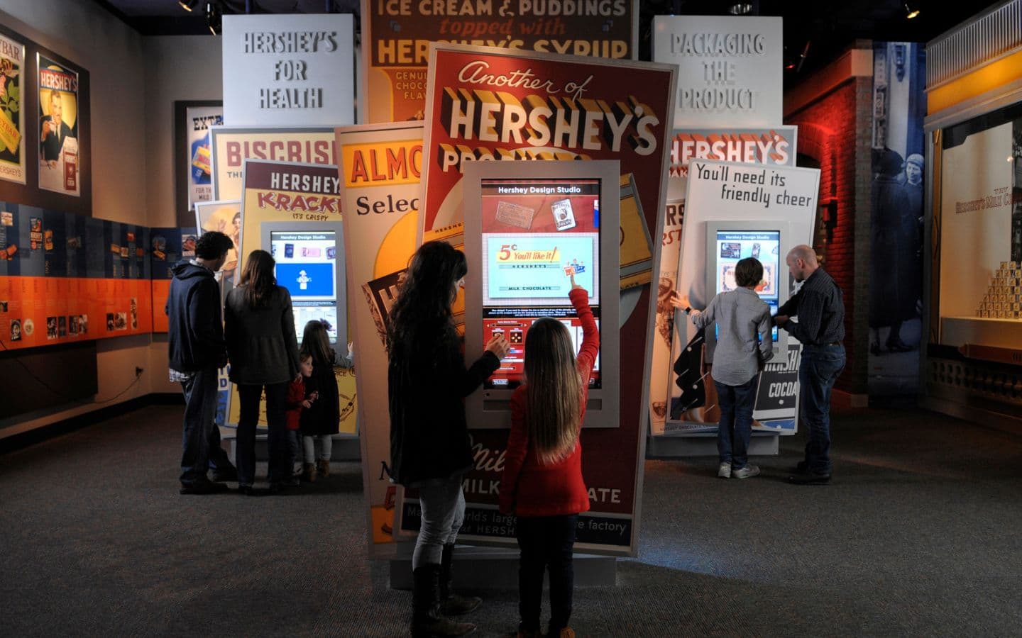 Visitors interact with exhibits in a Hershey's-themed display area.