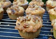 A close-up of freshly baked muffins topped with nuts cooling on a wire rack.