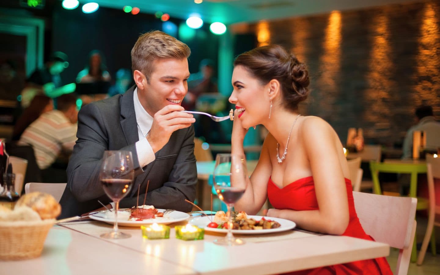 A couple shares a romantic moment over dinner in a cozy restaurant.