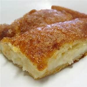 A golden-brown baked dessert bar with a soft, creamy filling.