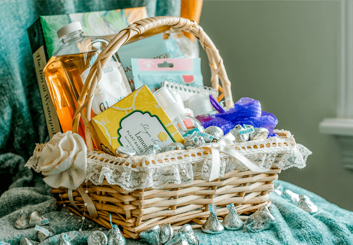 A wicker basket filled with various beauty and wellness products, surrounded by chocolate kisses.