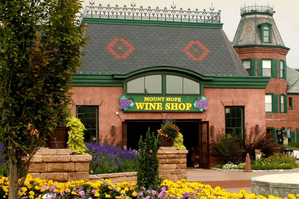 A charming wine shop with colorful flowers and a decorative roof.