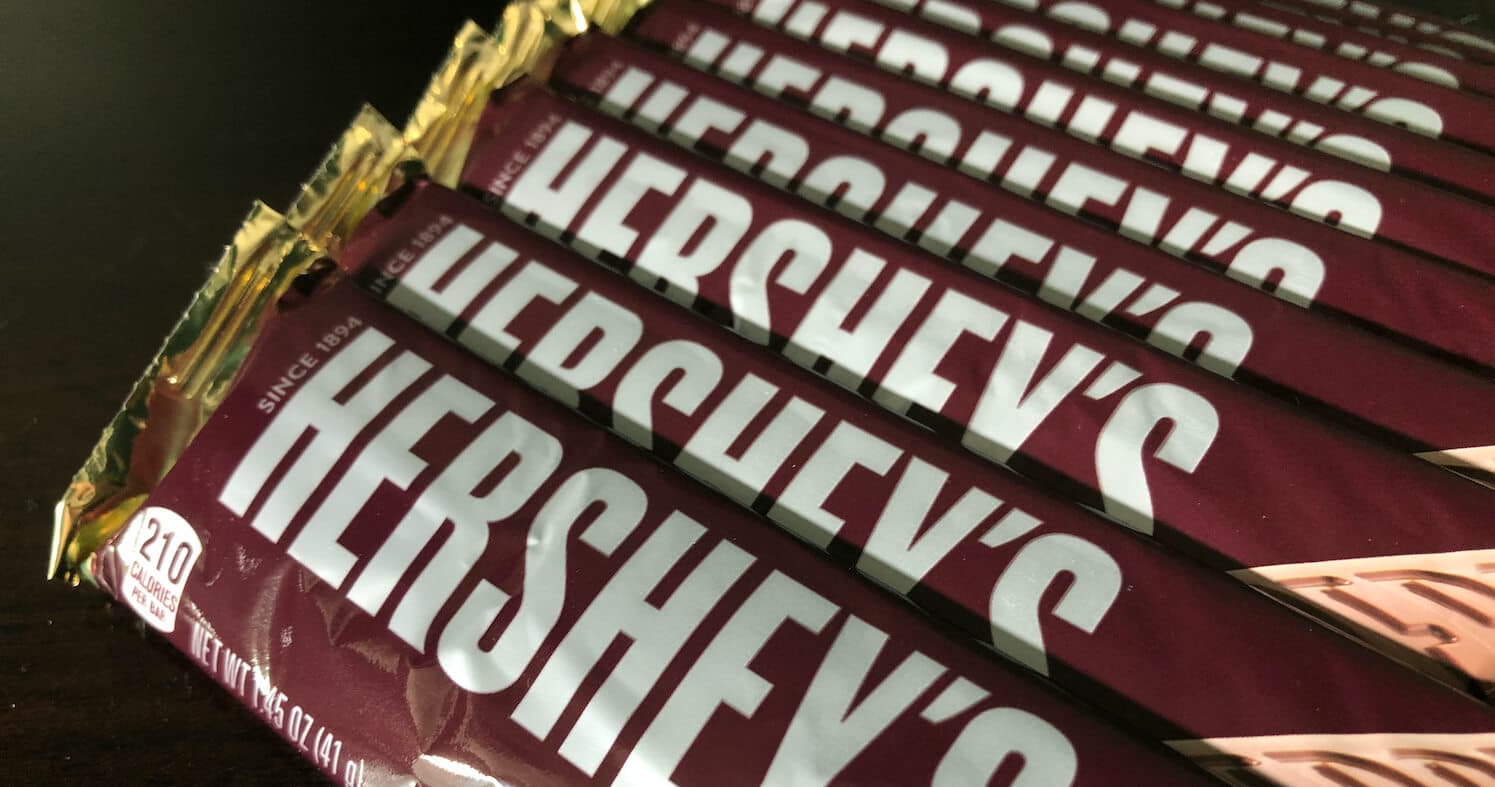 Several wrapped Hershey's chocolate bars lined up in a row. Several wrapped Hershey's chocolate bars lined up in a row.