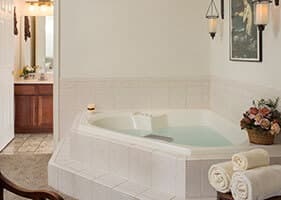 two person corner jacuzzi with wall art and electric candles