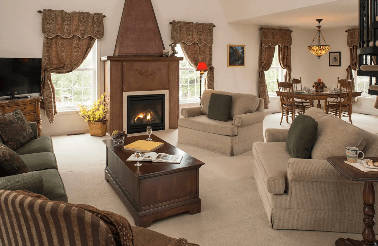 Cozy living room featuring a fireplace, comfortable seating, and a dining area.