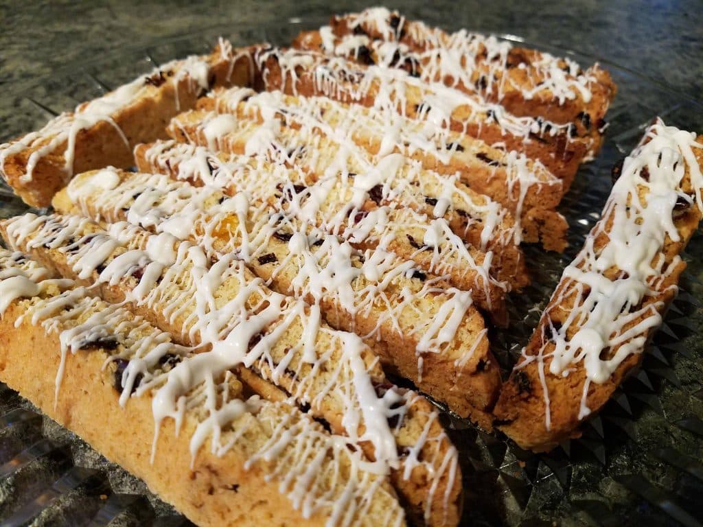 A plate of sliced biscotti drizzled with white icing.