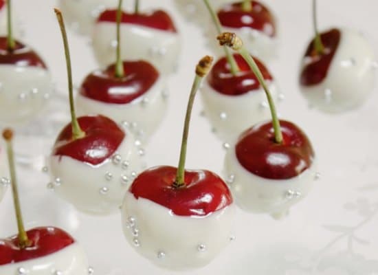 A cluster of cherries dipped in white chocolate and decorated with silver beads.