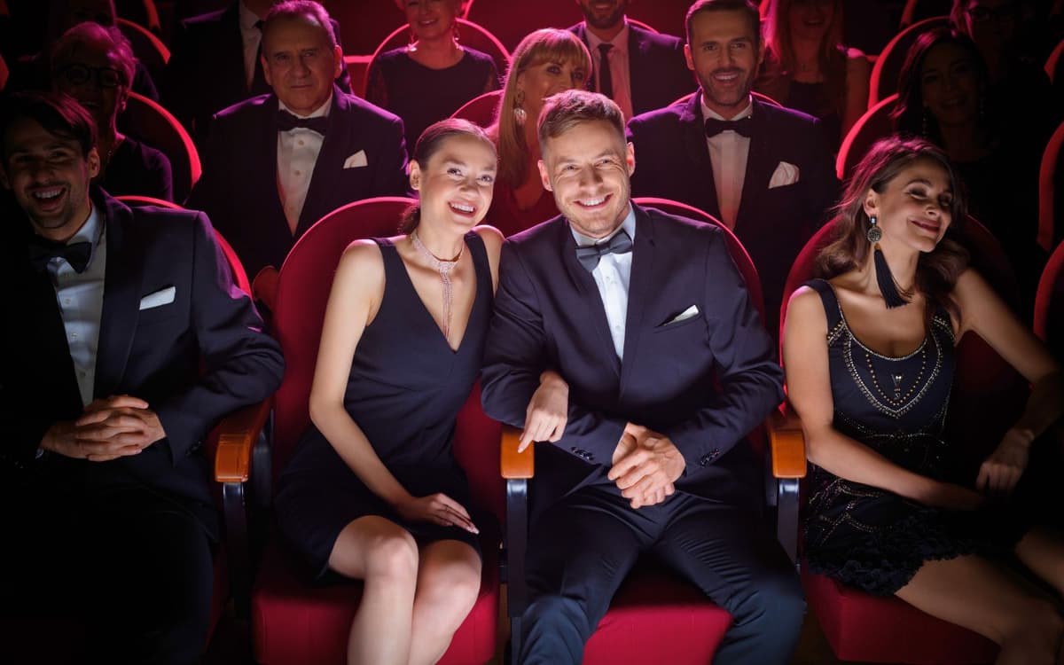 smiling couple watching theatrical performance in audience