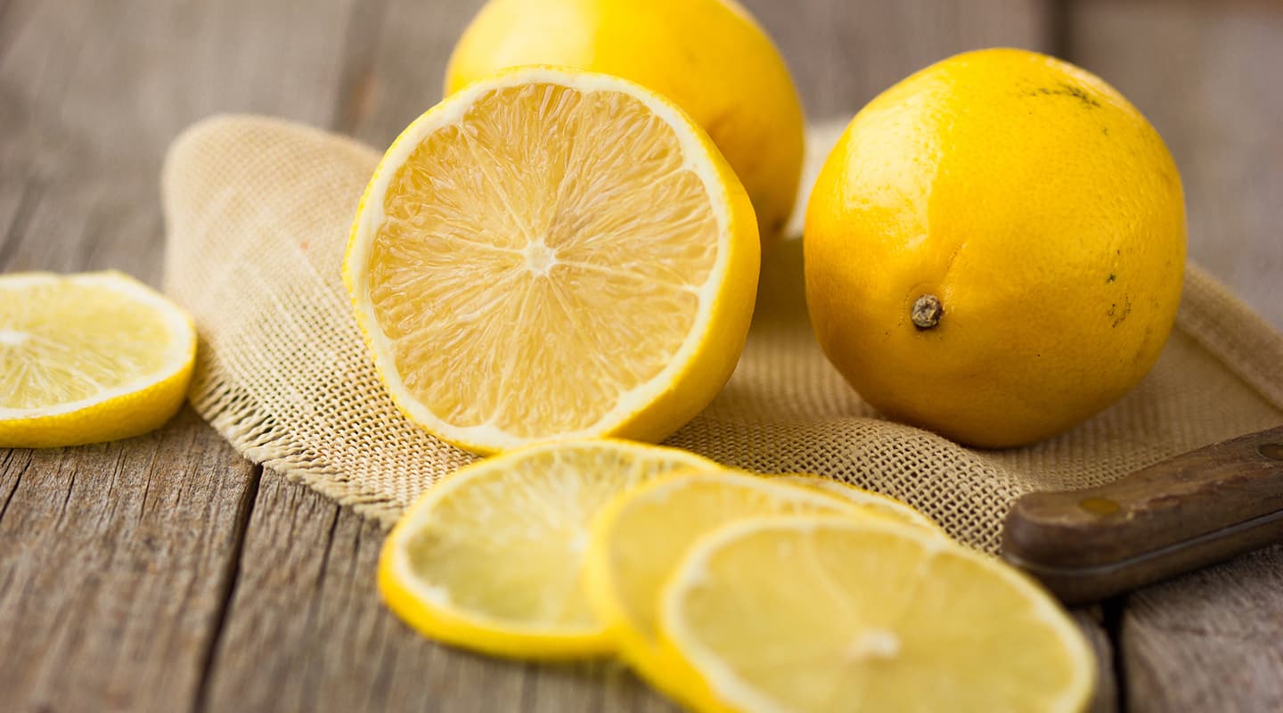 Freshly-cut lemon slices and half on small cloth on kitchen table