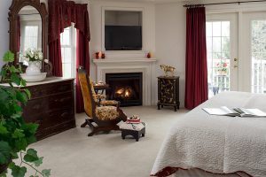Antique chair by fireplace and bed