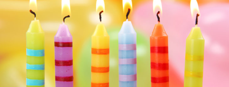 Six birthday candles on a colorful background