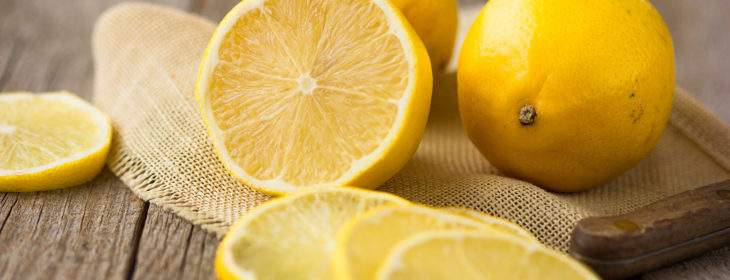 Freshly-cut lemon slices and half on small cloth on kitchen table