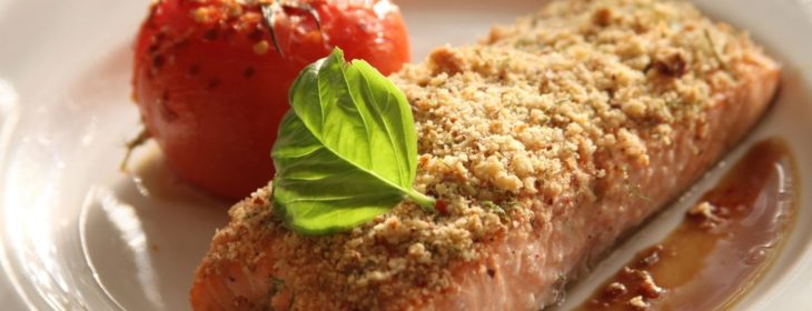 Plate of baked salmon with crispy topping crust and drizzled honey