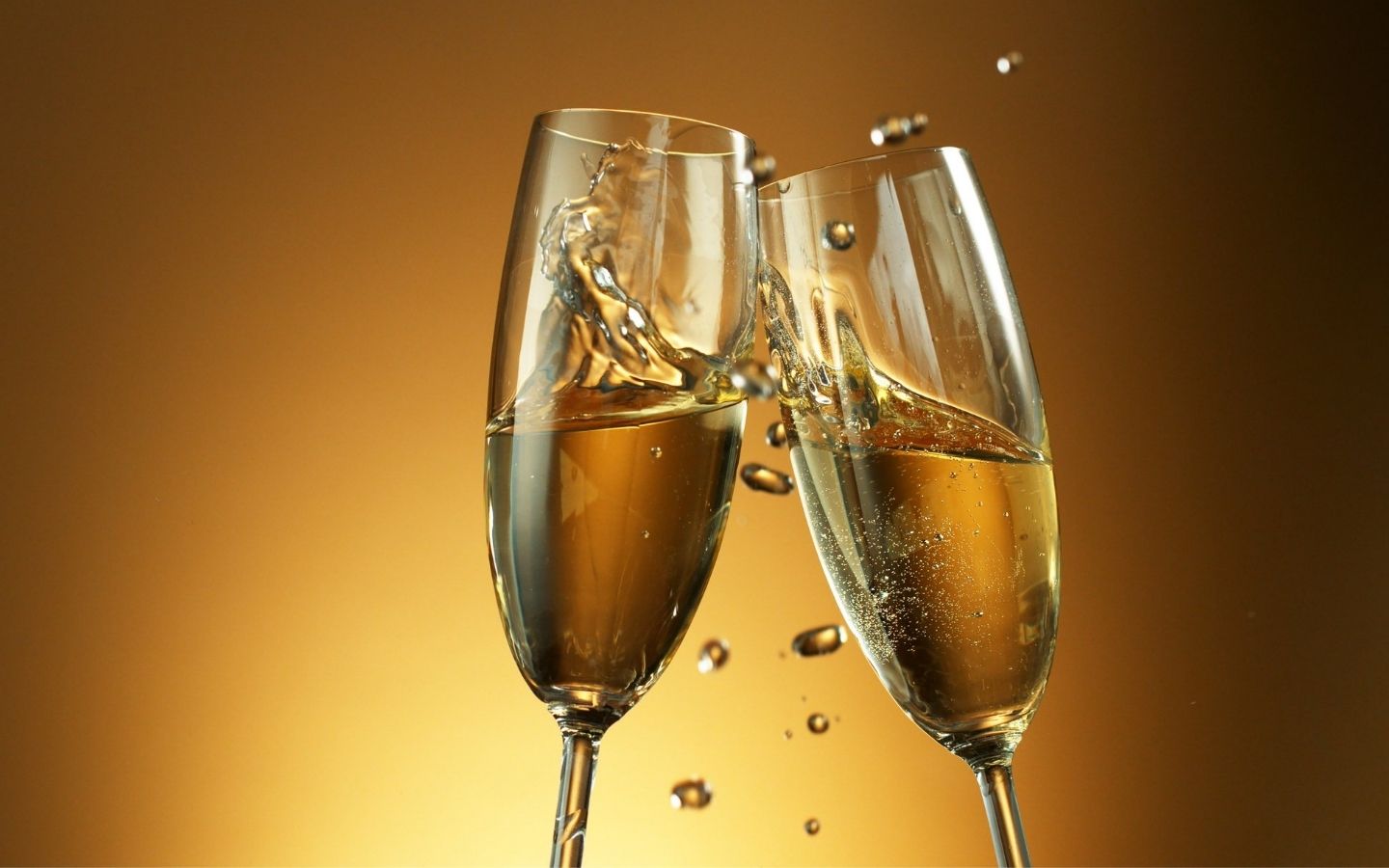 Two champagne glasses against a gold background
