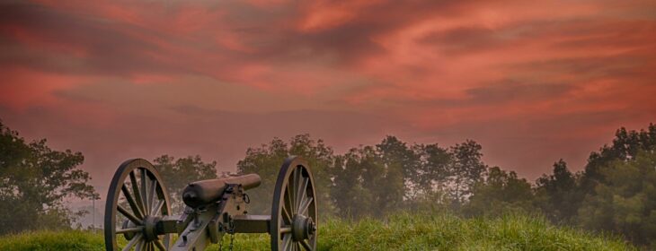 Civil war cannon against a red, sunset sky