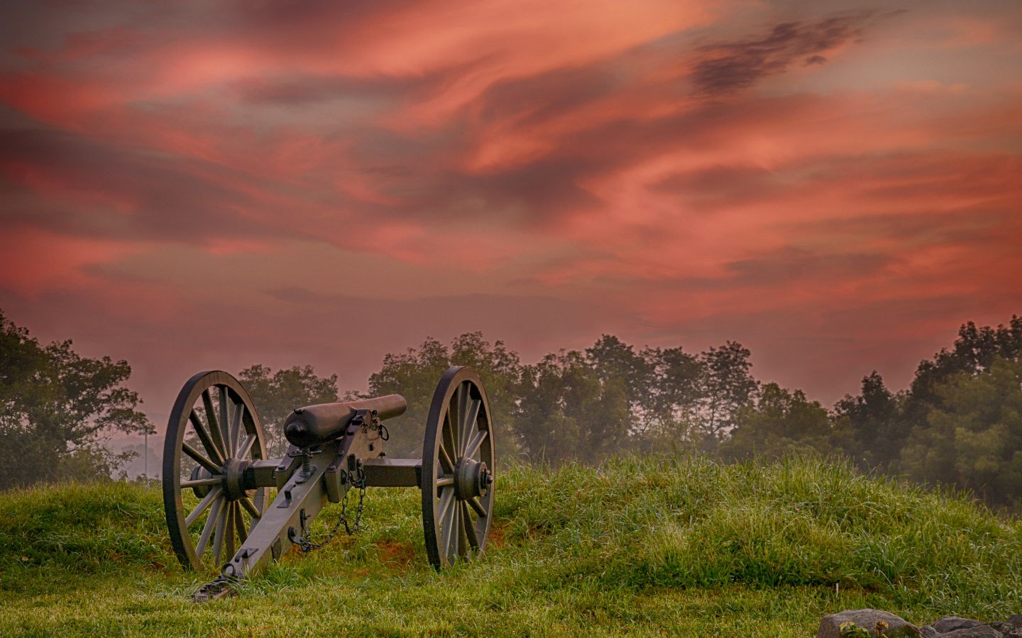 Civil war cannon against a red, sunset sky